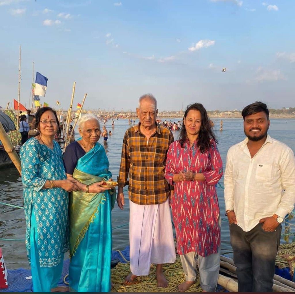 Family group standing next to the holy Ganga river at Sangam.